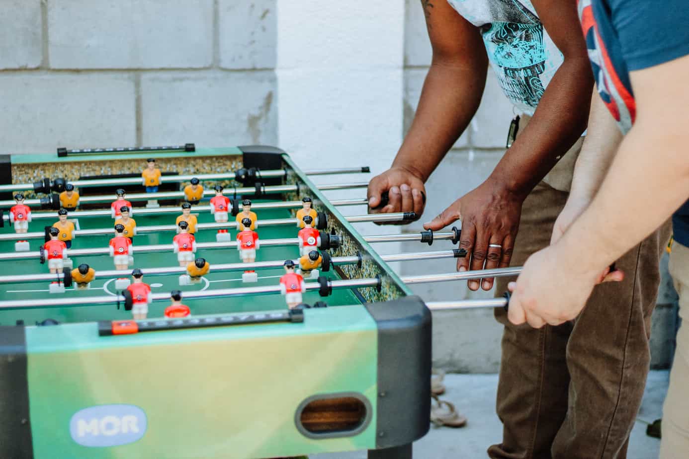 Where should the weaker player play in doubles foosball?